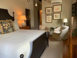 新奥尔良Terrell House Bed and Breakfast的一间卧室配有一张大床和两把椅子