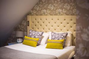 牛顿艾克利夫雷德沃斯大厅酒店 - 凯恩系列的一间卧室配有一张带黄色枕头的大床