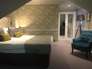 牛顿艾克利夫雷德沃斯大厅酒店 - 凯恩系列的一间卧室配有一张床和一张蓝色椅子