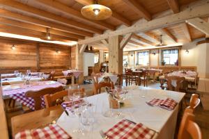 布兰兹I Riviù的餐厅设有白色的桌椅和木制天花板。