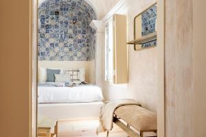 里斯本Archi-Pelago Alfama Design Suites Guesthouse的一间卧室配有蓝色和白色瓷砖