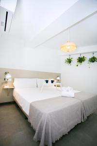 多列毛利诺斯MONKÓ - COCO & TROPYCAL APARTMENT o的白色卧室配有一张大床和吊灯