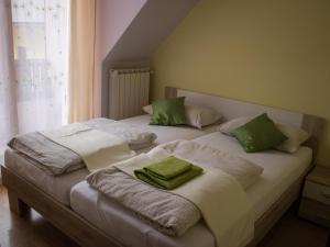 博维茨Apartments Kravanja的一间卧室配有两张带绿色枕头的床。