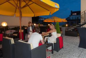 格尔利茨欧罗巴酒店的一群人坐在桌子上,在伞下