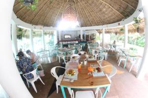 巴亚尔塔港Hotel Casa Iguana Mismaloya的一间带桌椅和大伞的餐厅