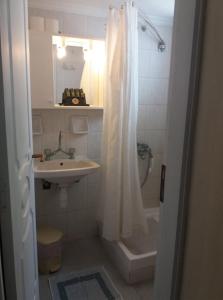 阿达玛斯帕拉斯伯罗思村公寓式酒店的浴室配有淋浴帘和盥洗盆。