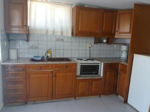 阿达玛斯帕拉斯伯罗思村公寓式酒店的厨房配有木制橱柜和炉灶烤箱。