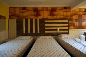 瓜鲁柳斯Motel Vison (Próximo GRU Aeroporto)的卧室设有两张木墙