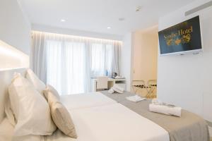 马翁Sindic Hotel - Adults Only的卧室设有一张白色大床和一扇窗户。