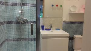 Angerville-lʼOrcherLa Polaris的浴室设有水槽和蓝色瓷砖淋浴。