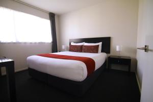 基督城瑞卡顿大都会汽车旅馆的一间设有大床和窗户的酒店客房
