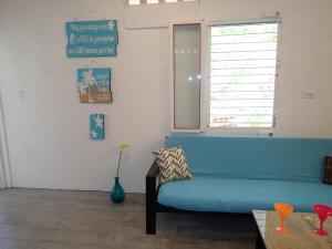 玛雅湾Simberts Apartments的客厅设有蓝色的沙发和窗户。