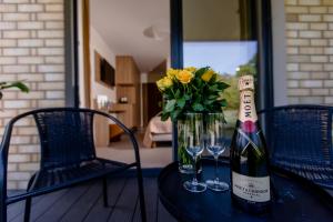 波别罗沃Matusz Apartamenty的一瓶葡萄酒和一瓶花在桌子上