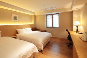 首尔梦之家酒店的酒店客房配有两张床和一张书桌