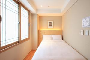 首尔梦之家酒店的窗户客房内的一张床位