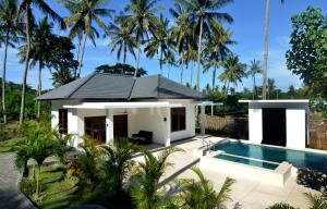 芒希Lombok from your Private Villa Sepuluh的一座白色的小房子,设有游泳池和棕榈树