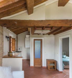 切奇纳Podere Il Polveroso的厨房和带木制天花板的客厅