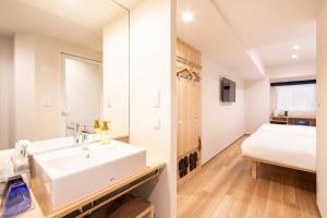 东京唐草酒店东京站的一间带水槽的浴室和一张位于客房内的床