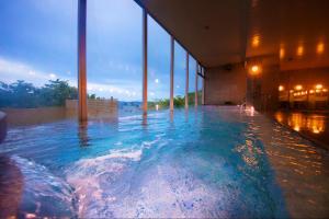 气仙沼市Kesennuma Plaza Hotel的大楼内一个蓝色的大型游泳池