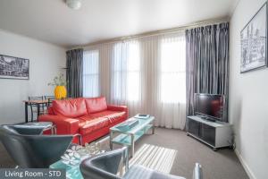 墨尔本Clocktower Apartment Hotel的客厅配有红色沙发和电视