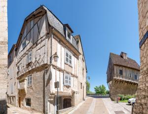 佩里格L' échafaud - Apparts de standing - Centre historique的一座古老的石头建筑,后面有一座塔