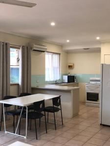 卡尔巴里鹈鹕巢旅馆的厨房配有桌椅和冰箱。