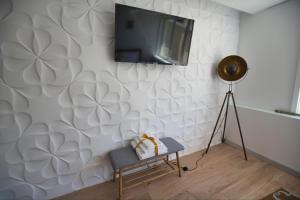 布拉干萨Camoes StudioGeral的一间客厅,在白色的墙上配有电视