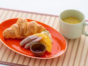 涩川市Hotel Waraku Shibukawa的盘子,上面有香肠和面包,还有一杯汤