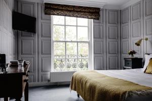 都柏林彭布罗克联排别墅酒店的一间卧室设有一张床和一个大窗户