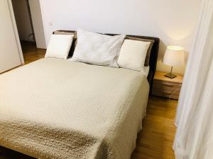 维也纳Amazing Austria Center Apartment near UNO City的一间卧室配有一张床和一盏灯,铺有木地板