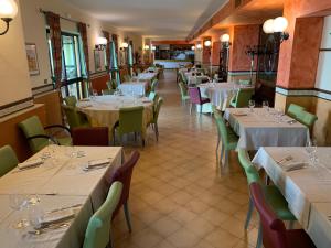 蒙蒂菲阿斯科尼拉卡罗扎多罗酒店的用餐室配有桌椅和白色的桌布