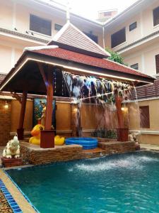 乔木提恩海滩Aiyaree Place Hotel SHA PLUS的一座房子里一个带喷泉的游泳池