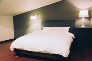 巨济GONGGAN Residence Hotel的卧室配有一张白色大床和两盏灯。