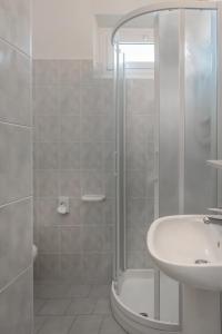 里米尼索尔米奥酒店的带淋浴和盥洗盆的白色浴室