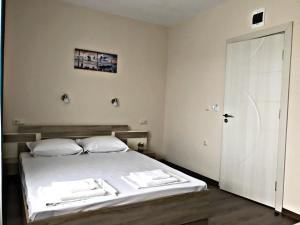 拉夫达"Бербатови 1"的卧室配有带白色床单的床和门。