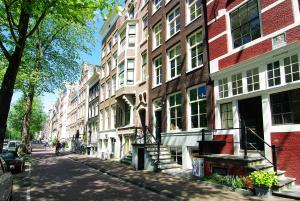 阿姆斯特丹1637: Historic Canal View Suites的阳光明媚的日子里,城市街道上高楼