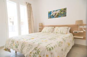 卡拉纳雅达Ca sa Padrina Barruana的一间卧室配有一张带花卉棉被的床