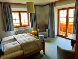 Radfeld兰格旅馆的一间卧室配有一张床、一把椅子和窗户。