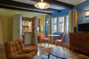 科尔马Maison Cliquot - Appartements Colmar Centre的客厅配有橙色椅子和桌子