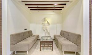 奥兰加巴德Treebo Trend Lalaji's Executive的带沙发和桌子的客厅中的雕像
