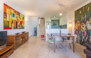 埃斯塔蒂特LA PLATERA " Seaview "的厨房以及带桌子和大画的用餐室。