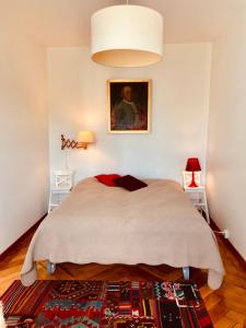 拉绍德封Appartement 1Bijou的卧室配有一张床,墙上挂有绘画作品