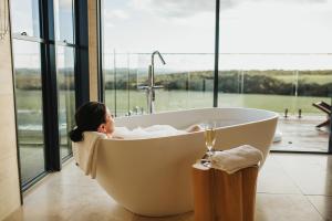 Stokes BayStowAway Kangaroo Island的躺在浴缸里的一个窗户房间里的一个女人