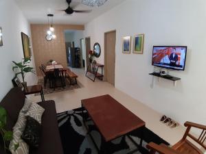 甘孟ORCHIDD HOMESTAY的客厅配有沙发和墙上的电视