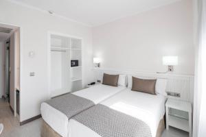 巴塞罗那加泰罗尼亚罗马酒店的白色卧室配有一张大床和椅子