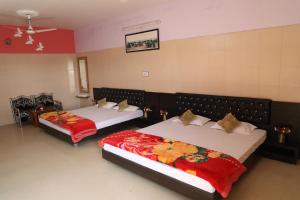 焦特布尔Shivam Palace & Resort的一间带两张红色毯子的卧室