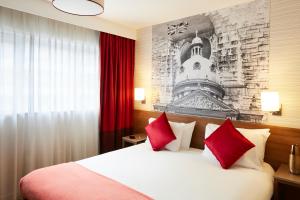 伯明翰伯明翰市中心阿德吉奥公寓式酒店的配有红色枕头的床的酒店客房