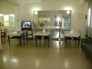 布宜诺斯艾利斯里尔斯普兰迪德酒店的一间带桌椅和电视的用餐室