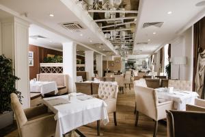 特鲁斯卡韦茨Hotel Alkor的餐厅设有白色的桌椅和白色的桌椅