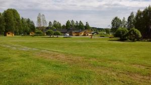 SukevaLohirannan lomakylä的一片大草场,有房子的背景